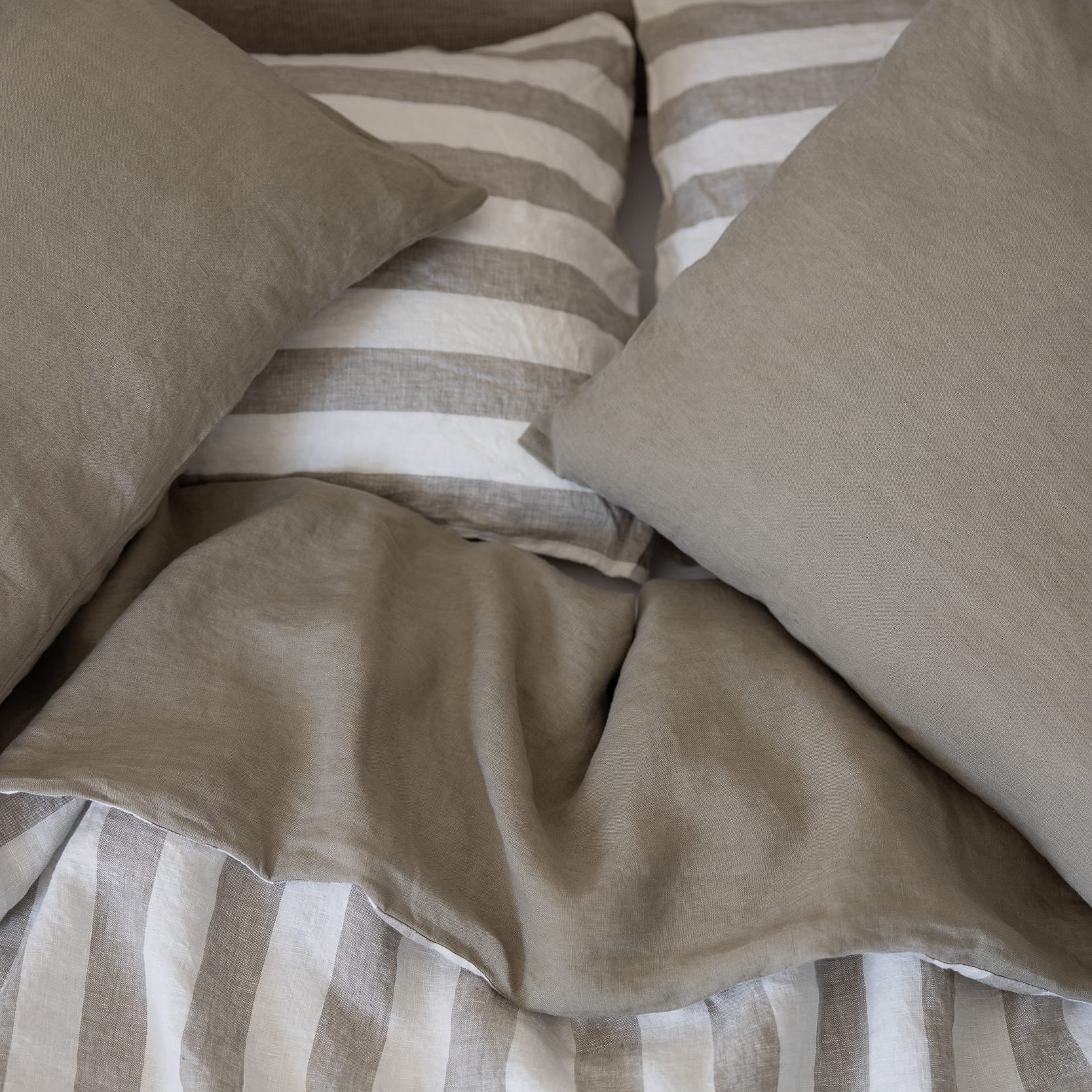 Tess pillowcases on top of a Tess and Stripe reversible linen duvet cover 